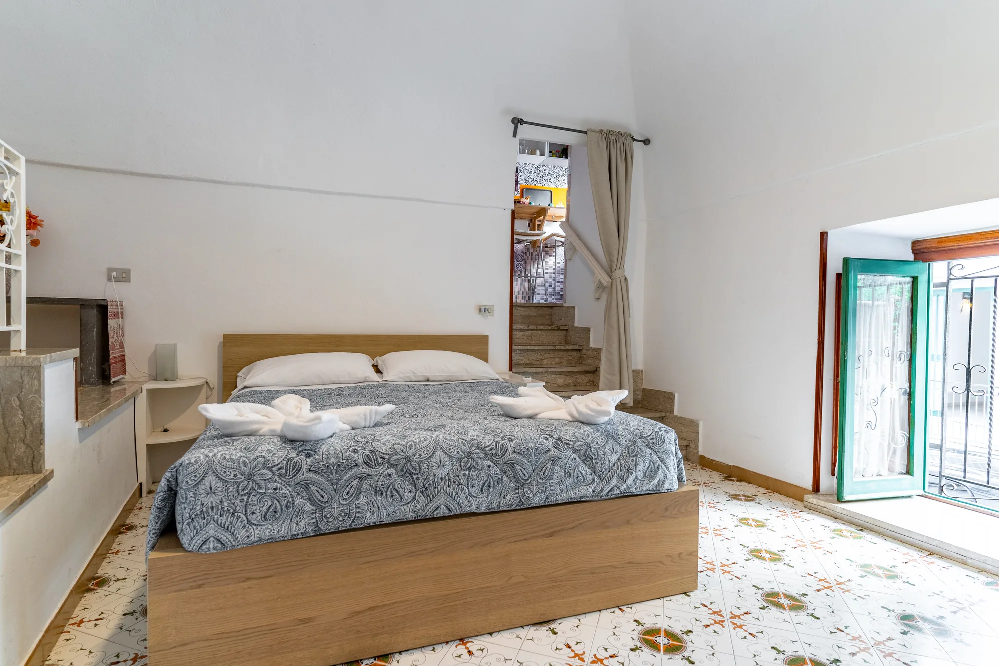 Guest room angle with bed, doorway and bright wall volume - interior photography on the Amalfi Coast by Cinereo