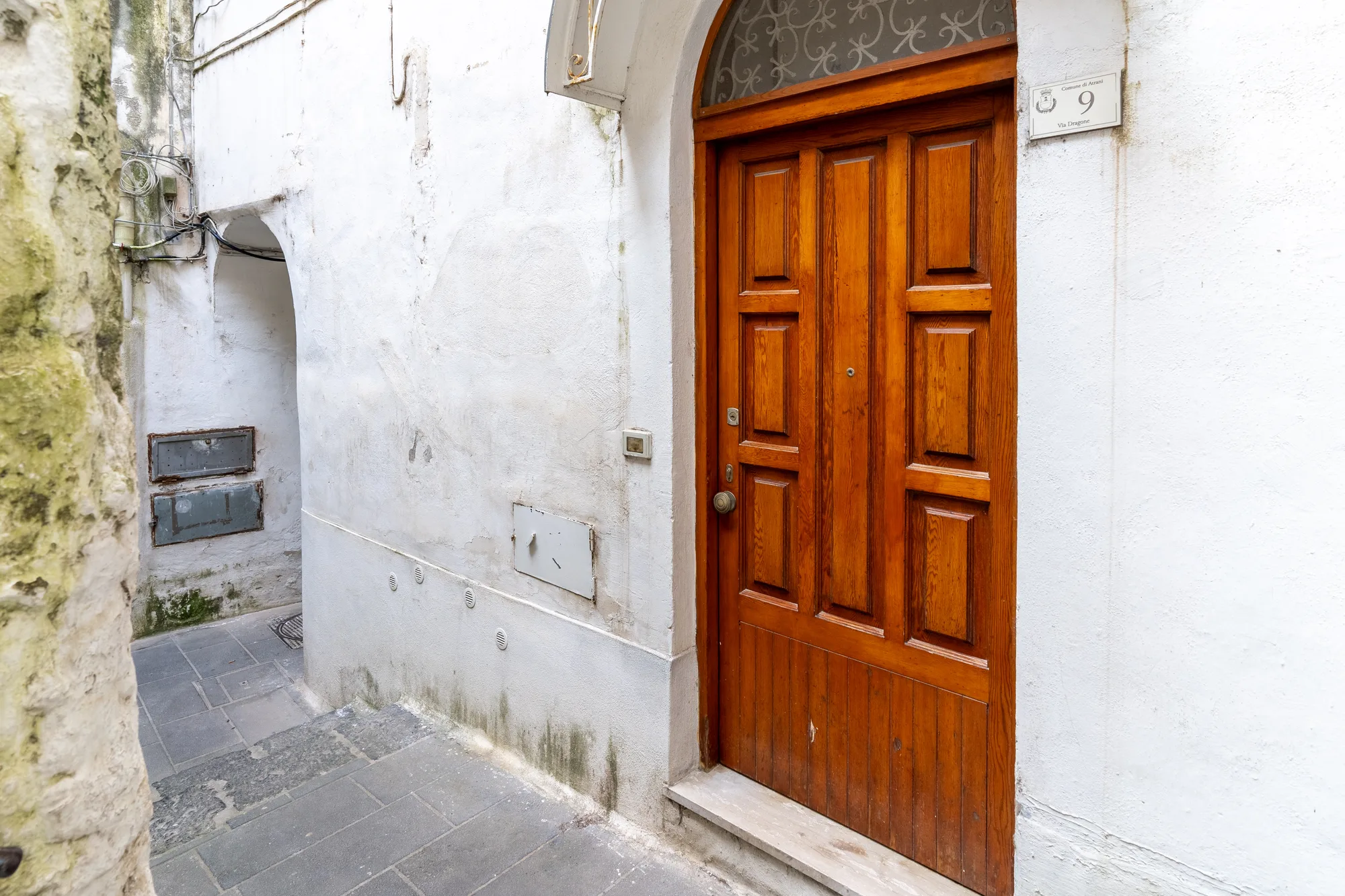 Stone entrance and wooden door photographed as part of the arrival story - interior photography on the Amalfi Coast by Cinereo