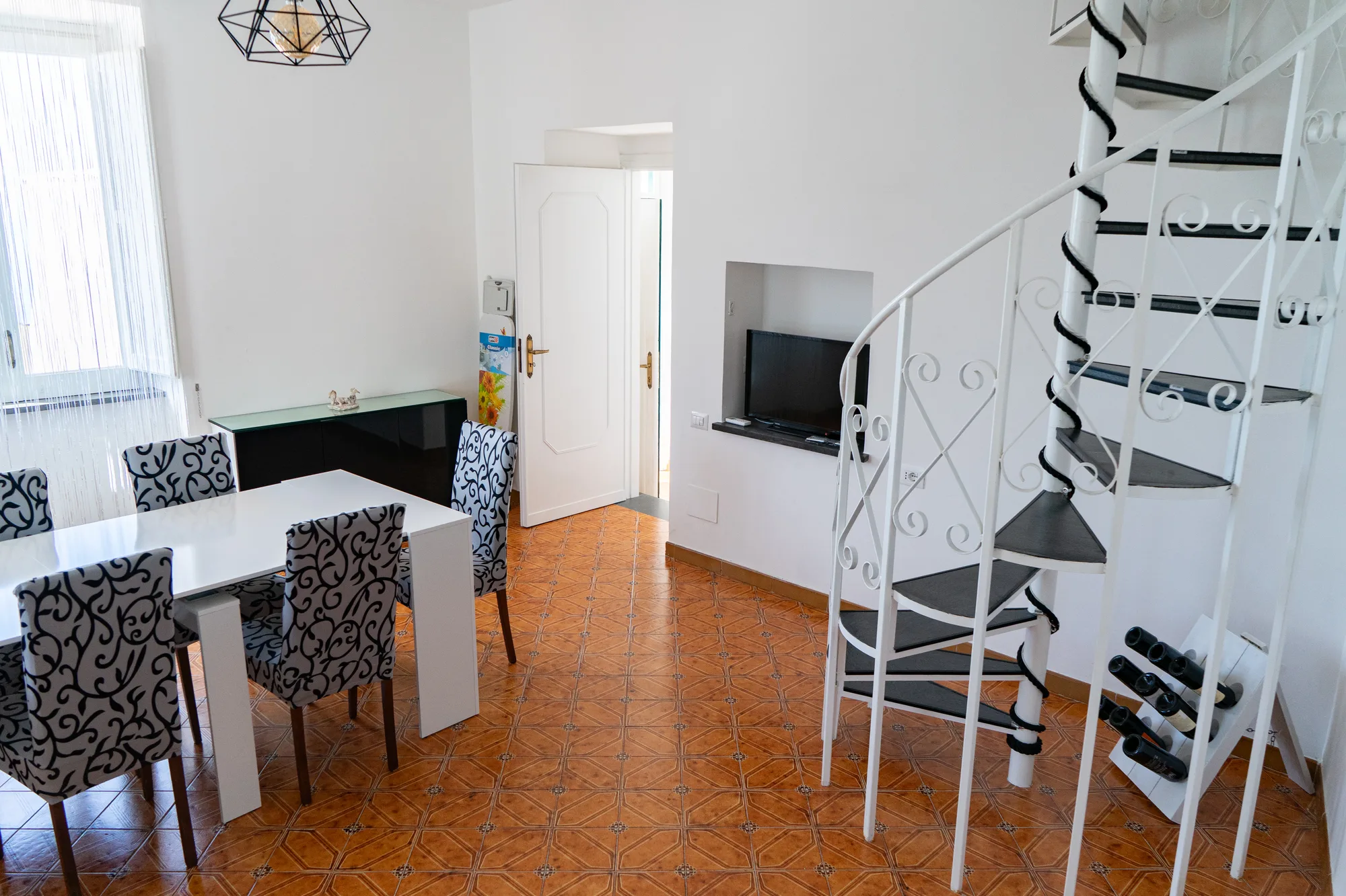 Living and dining area with staircase and bright white walls - interior photography on the Amalfi Coast by Cinereo