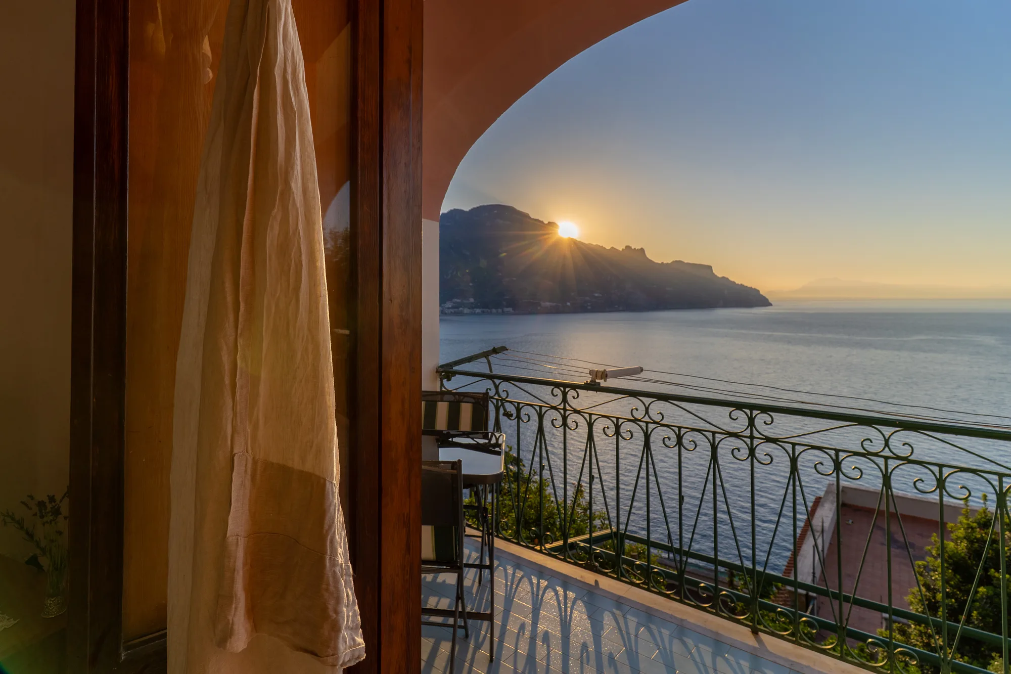 Balcony sunrise view framed by the apartment doorway - interior photography on the Amalfi Coast by Cinereo