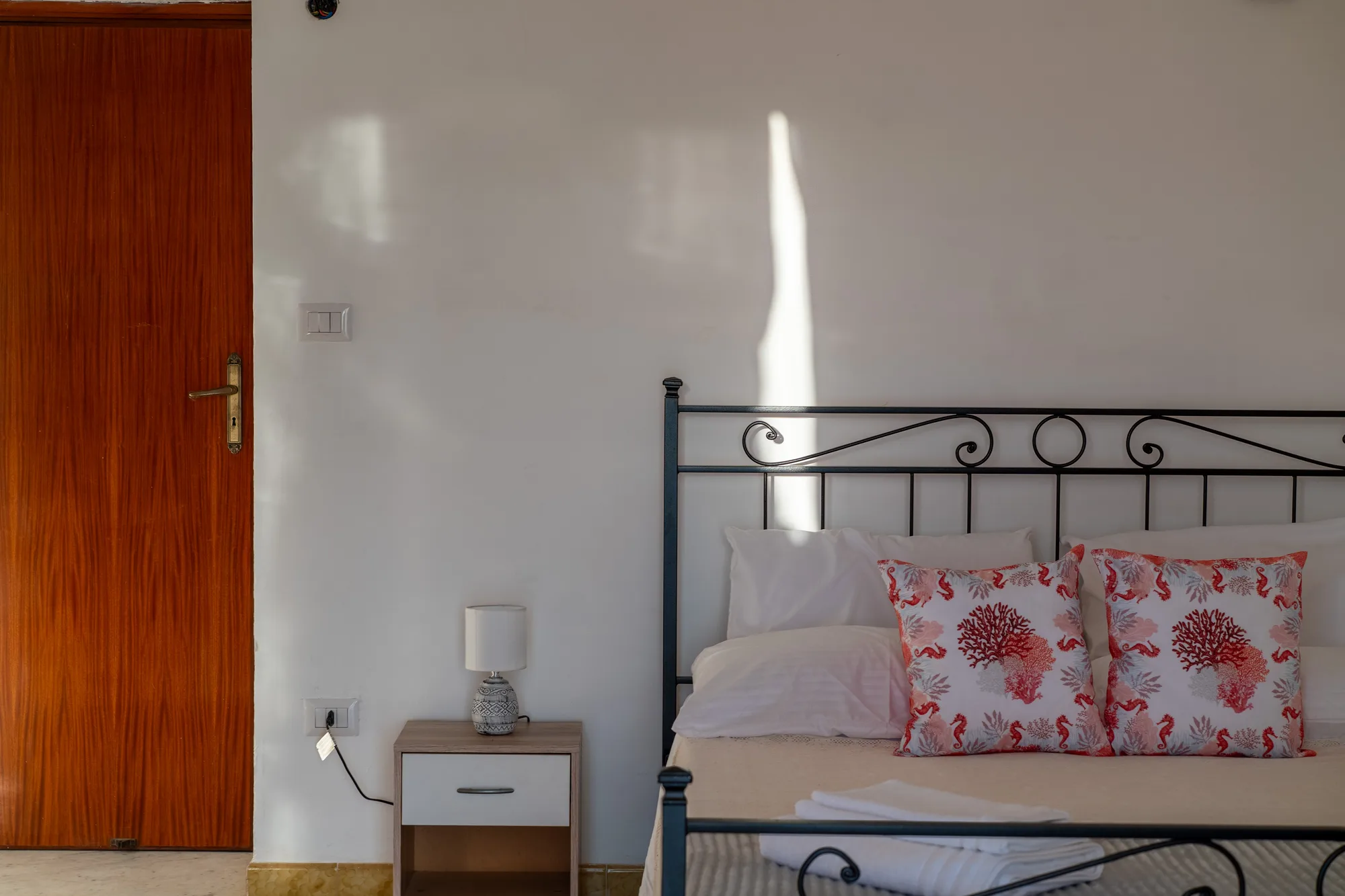 Bedside wall and headboard detail showing room scale - interior photography on the Amalfi Coast by Cinereo