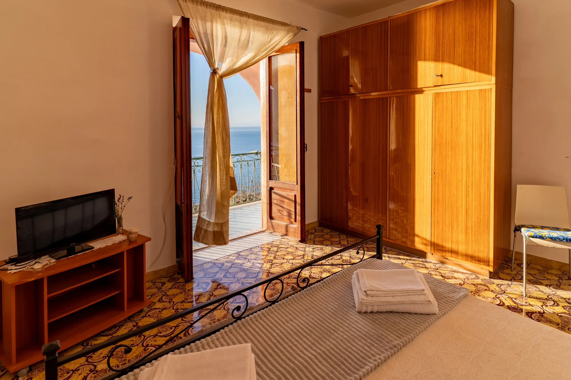 Bedroom and wardrobe angle with sea light entering the room - interior photography on the Amalfi Coast by Cinereo