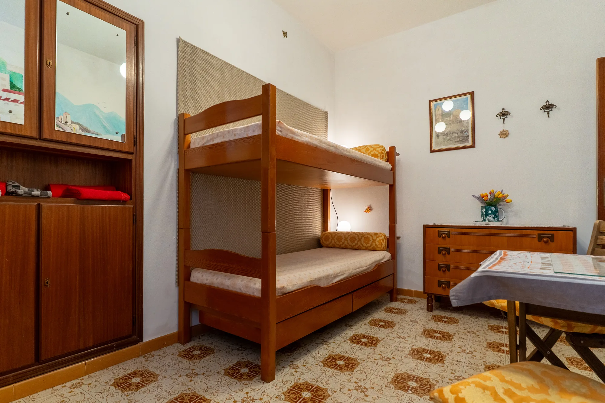 Compact sleeping room with bunkbeds, mirror and small dining table - interior photography on the Amalfi Coast by Cinereo