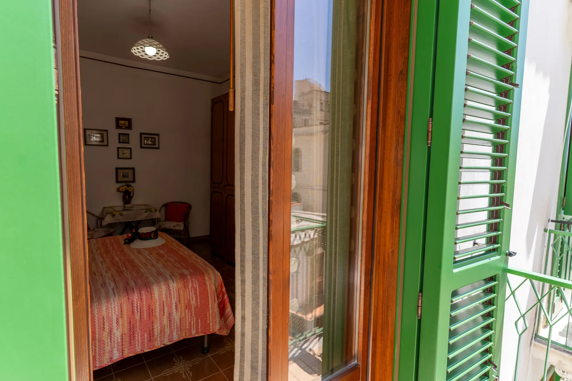 Green shutters framing the room from the balcony - interior photography on the Amalfi Coast by Cinereo