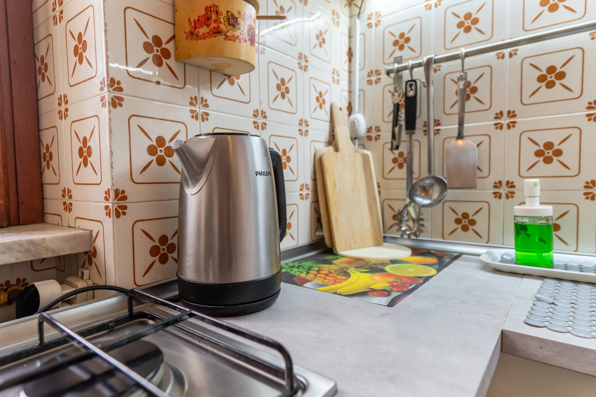 Worktop detail with kettle, utensils and patterned ceramic tiles - interior photography on the Amalfi Coast by Cinereo
