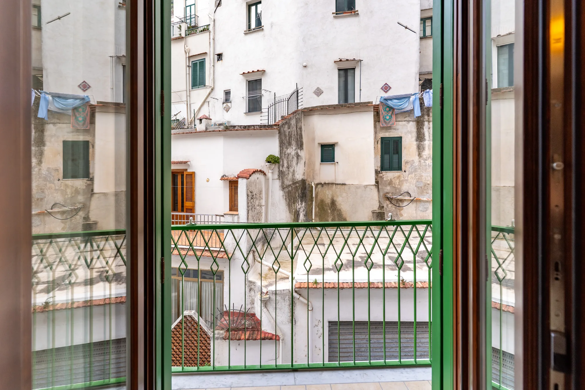 Atrani balcony view framed through open doors - interior photography on the Amalfi Coast by Cinereo