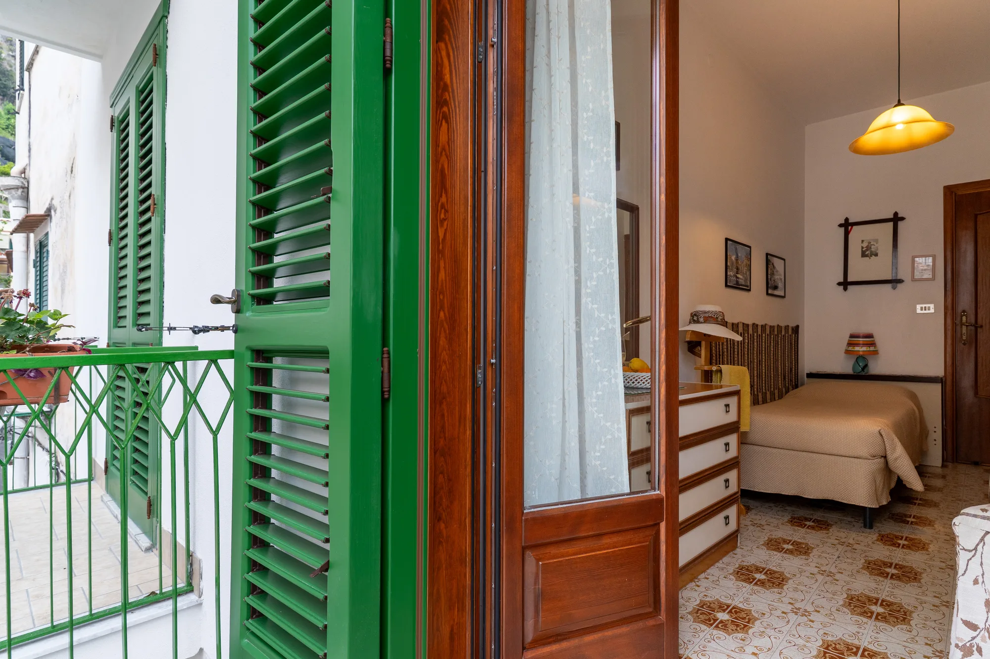 Green shutters and balcony light leading back into the room - interior photography on the Amalfi Coast by Cinereo